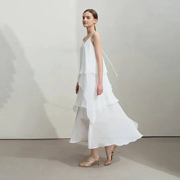 Woman wearing a white dress with a plain background, featuring the brand 'Amii'.