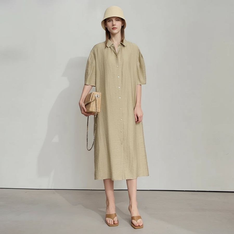 Woman wearing a beige dress and hat with a wooden handbag on a white background, featuring the brand 'Amii'.