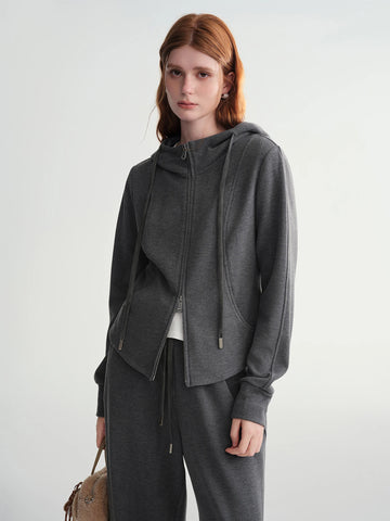 Woman wearing a gray hoodie and pants with a white background