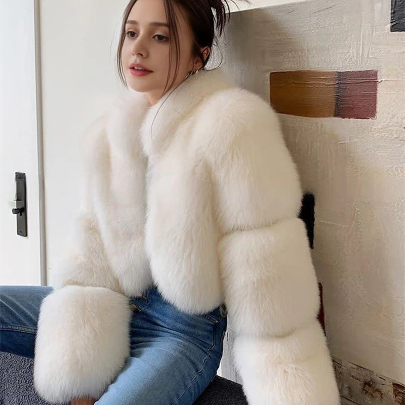 Person wearing a white fluffy coat sitting on a staircase.