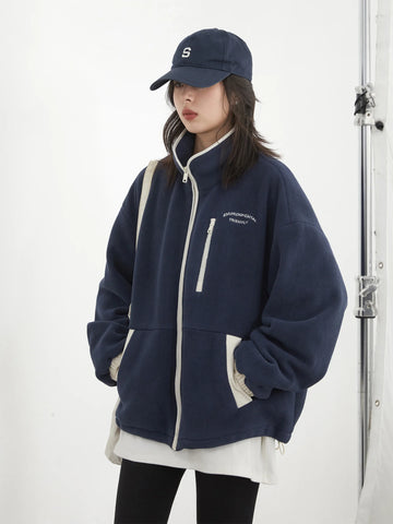 Person wearing a navy blue jacket and cap on a white background