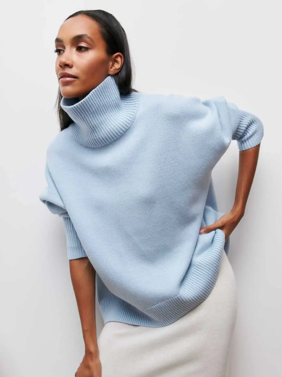Woman wearing a light blue turtleneck sweater against a white background