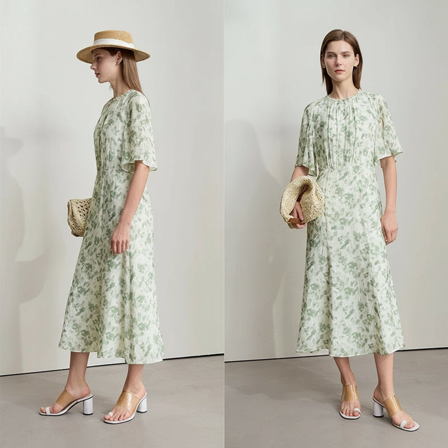 Woman wearing a green floral dress with a plain background, featuring the brand AMH.