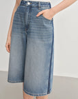 Denim skirt worn by a person on a plain background