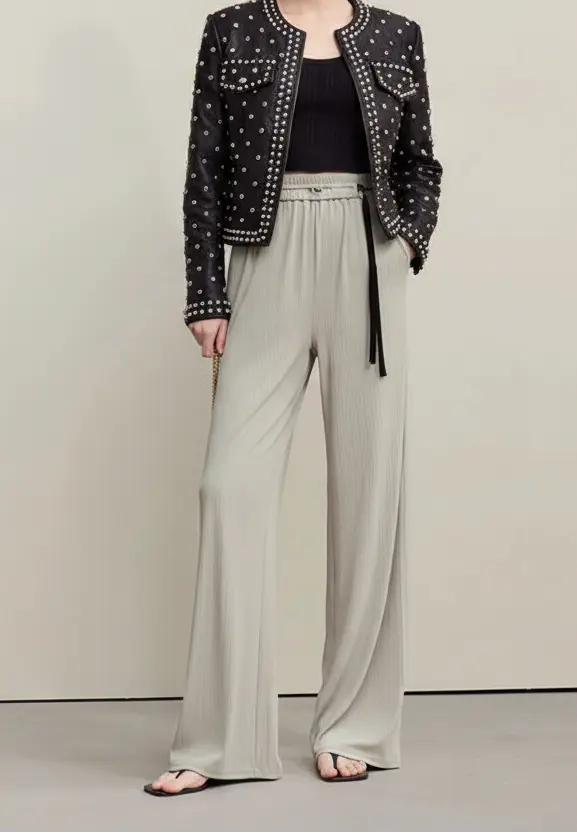 Person wearing light gray wide-leg pants with a plain background