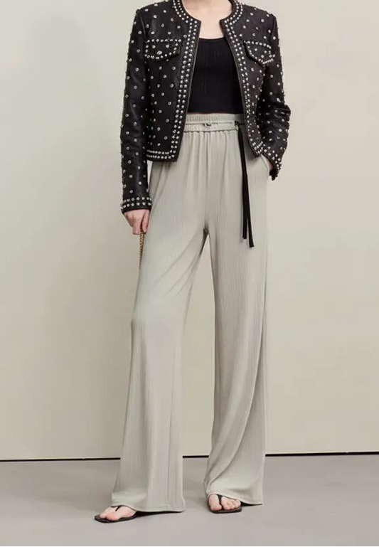 Person wearing light gray wide-leg pants with a plain background