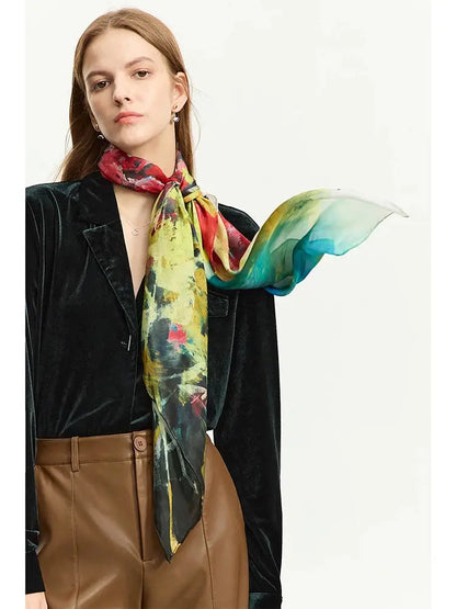 Woman wearing a colorful scarf with a black blazer and brown pants on a white background
