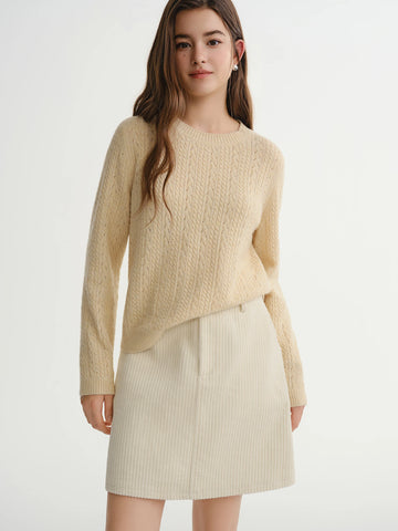 Woman wearing a beige sweater and skirt on a white background