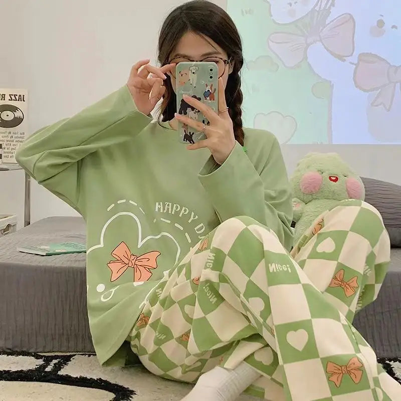 Person wearing a green outfit with cartoon designs, sitting on a bed.