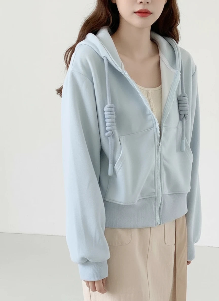 Light blue hoodie worn by a person with a neutral background
