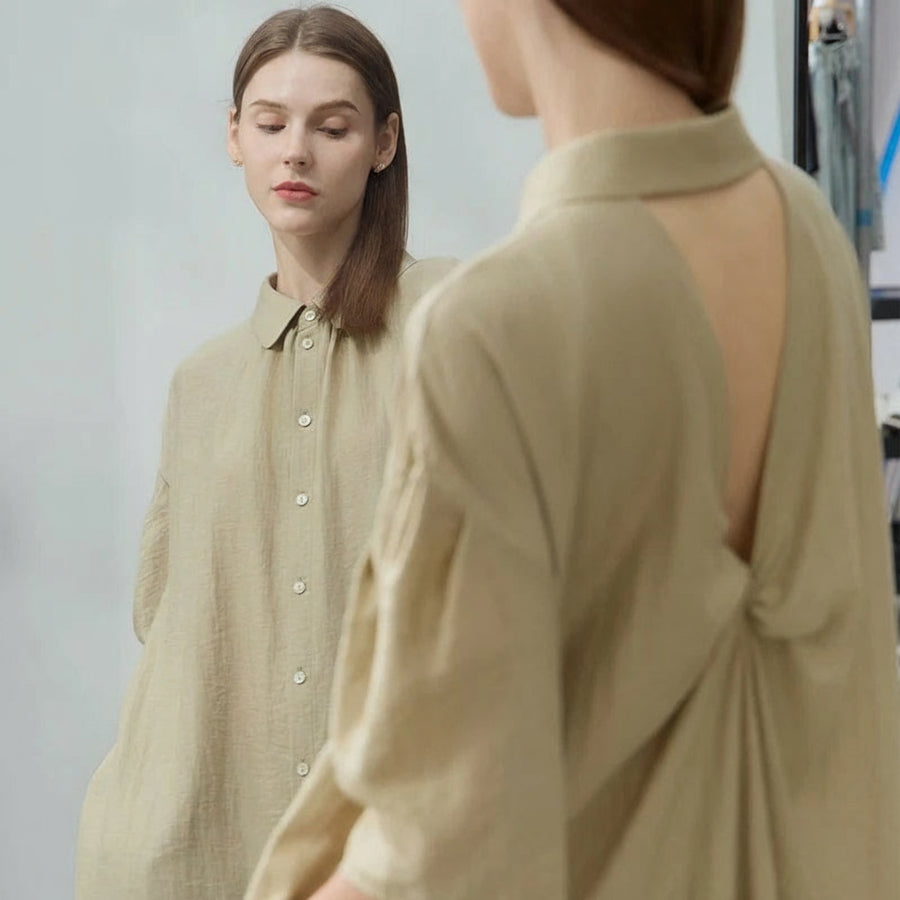 Woman wearing a beige open-back dress with 'Amii' branding.