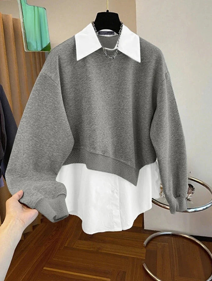 Gray sweater with white collar and cuffs on a hanger