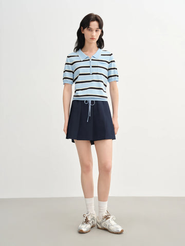 Woman wearing a striped shirt and navy skirt on a white background