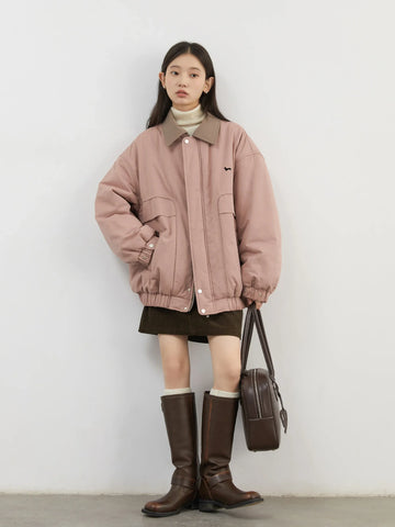 Person wearing a pink jacket and brown boots against a white background