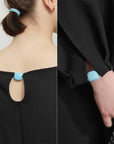 Black garment with blue fluffy details on neckline and cuffs, brand 'Amii' visible.