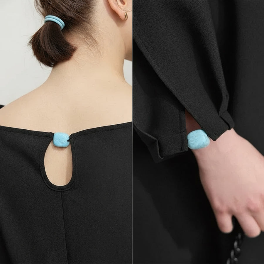 Black garment with blue fluffy details on neckline and cuffs, brand 'Amii' visible.