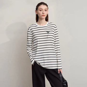 Person wearing a black and white striped long-sleeve shirt against a plain background