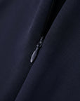 Close-up of a zipper on a dark fabric with Amii logo.
