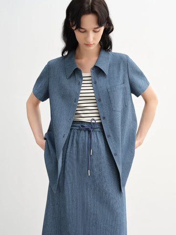 Woman wearing a blue denim outfit with a white background