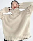 Person wearing a beige turtleneck sweater against a white background