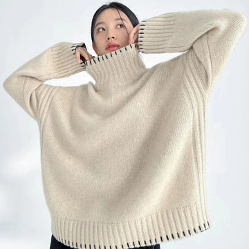 Person wearing a beige turtleneck sweater against a white background