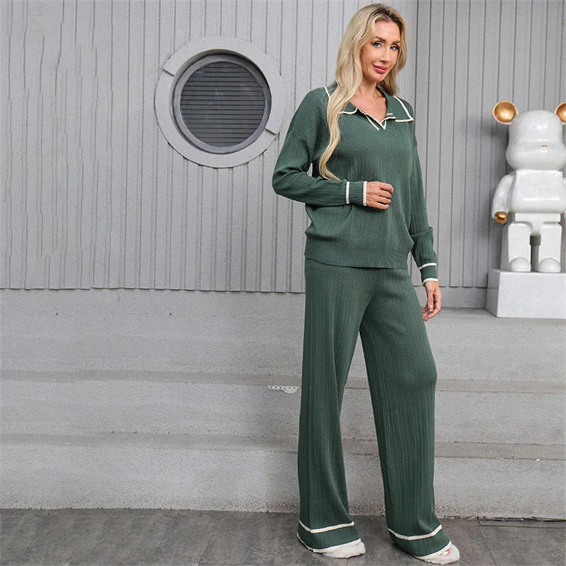 Woman wearing a green pajama set standing in front of a gray wall with a decorative robot figure.