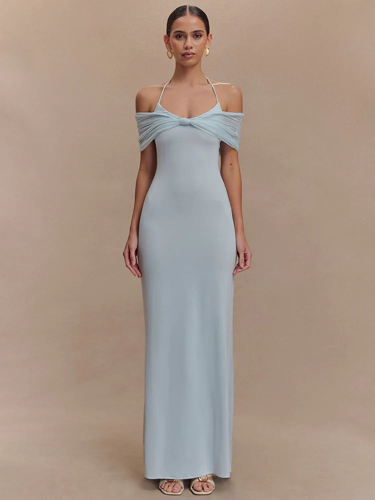 Woman wearing a light blue gown against a beige background