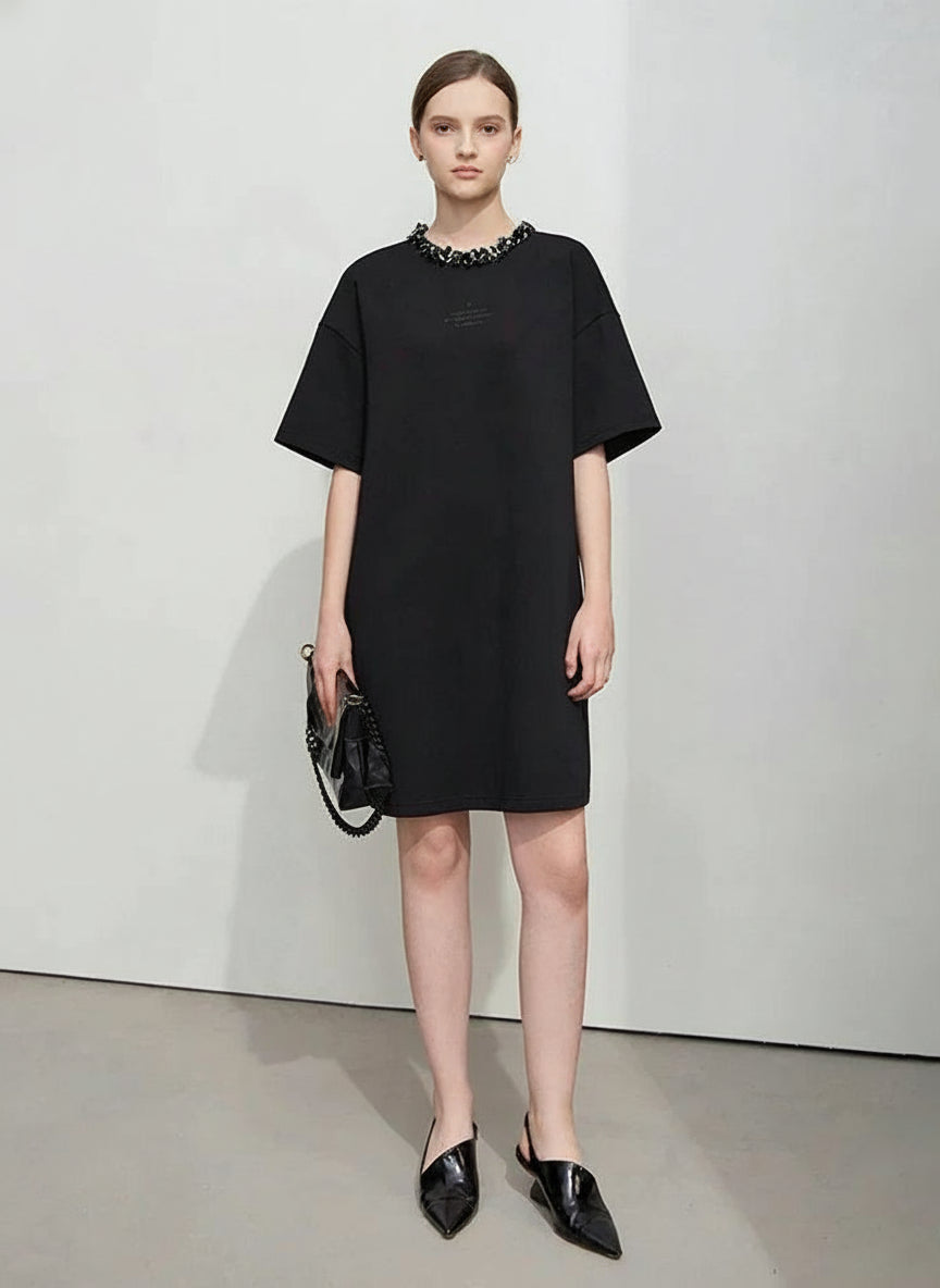 Woman wearing a black dress with a white background, featuring the AMII brand.