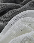 Close-up of textured fabric in gray and white with 'Amii' brand logo.