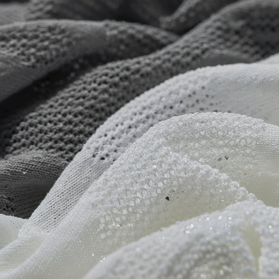 Close-up of textured fabric in gray and white with 'Amii' brand logo.