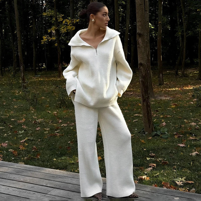 Woman in a white outfit standing on a wooden platform in a forest setting