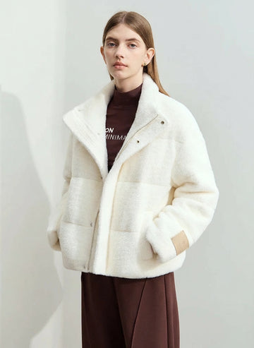 Woman wearing a white puffer jacket with a plain background, featuring the AMII brand.