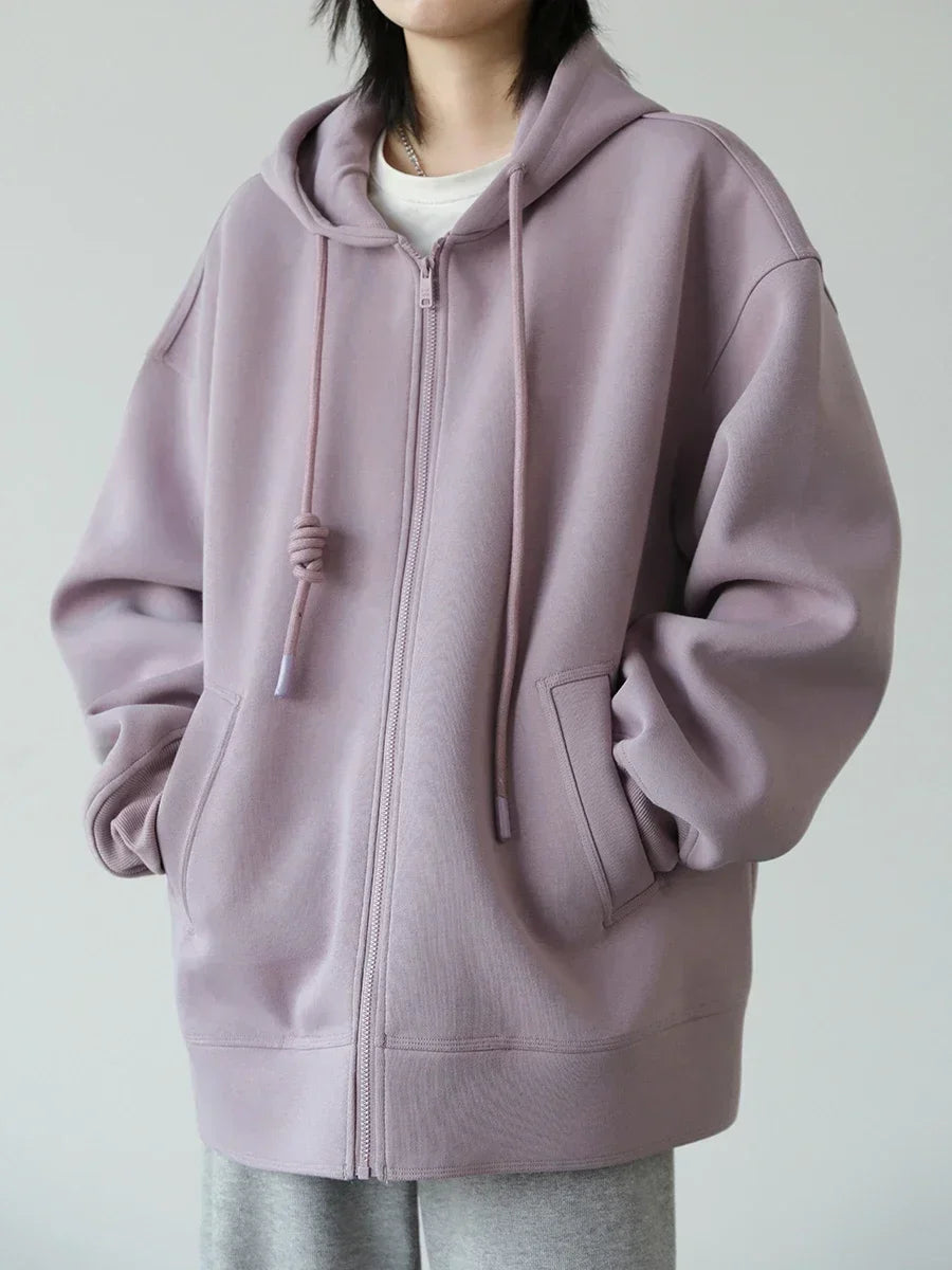 Person wearing a light purple hoodie on a plain background