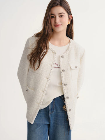 Woman wearing a light gray jacket over a white shirt and blue jeans on a white background