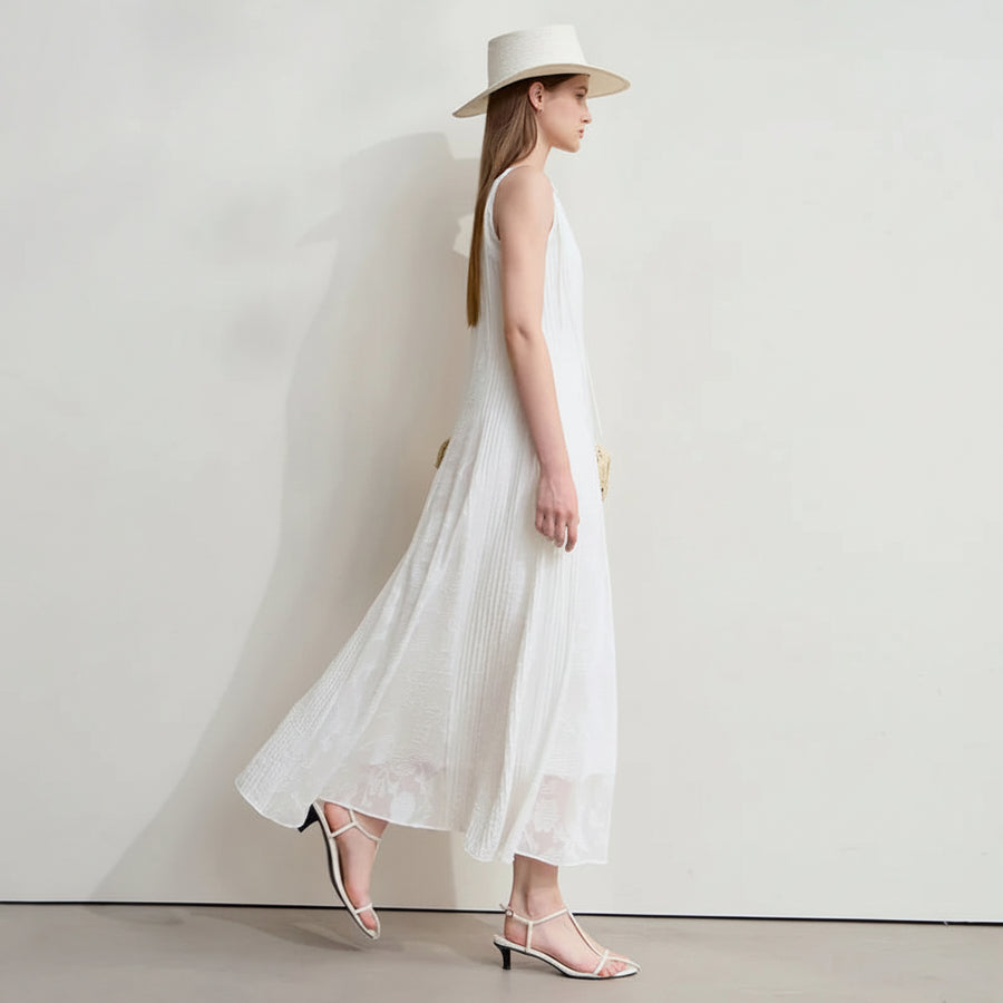 Woman wearing a white dress and hat against a plain background with AMII branding.