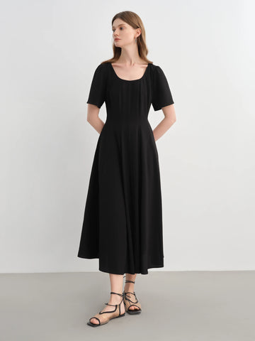 Woman wearing a black dress against a white background