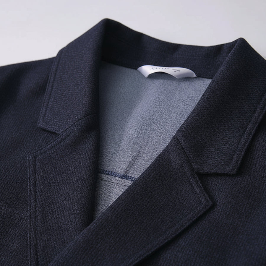 Blue denim jacket with a close-up of the collar and label on a light gray background