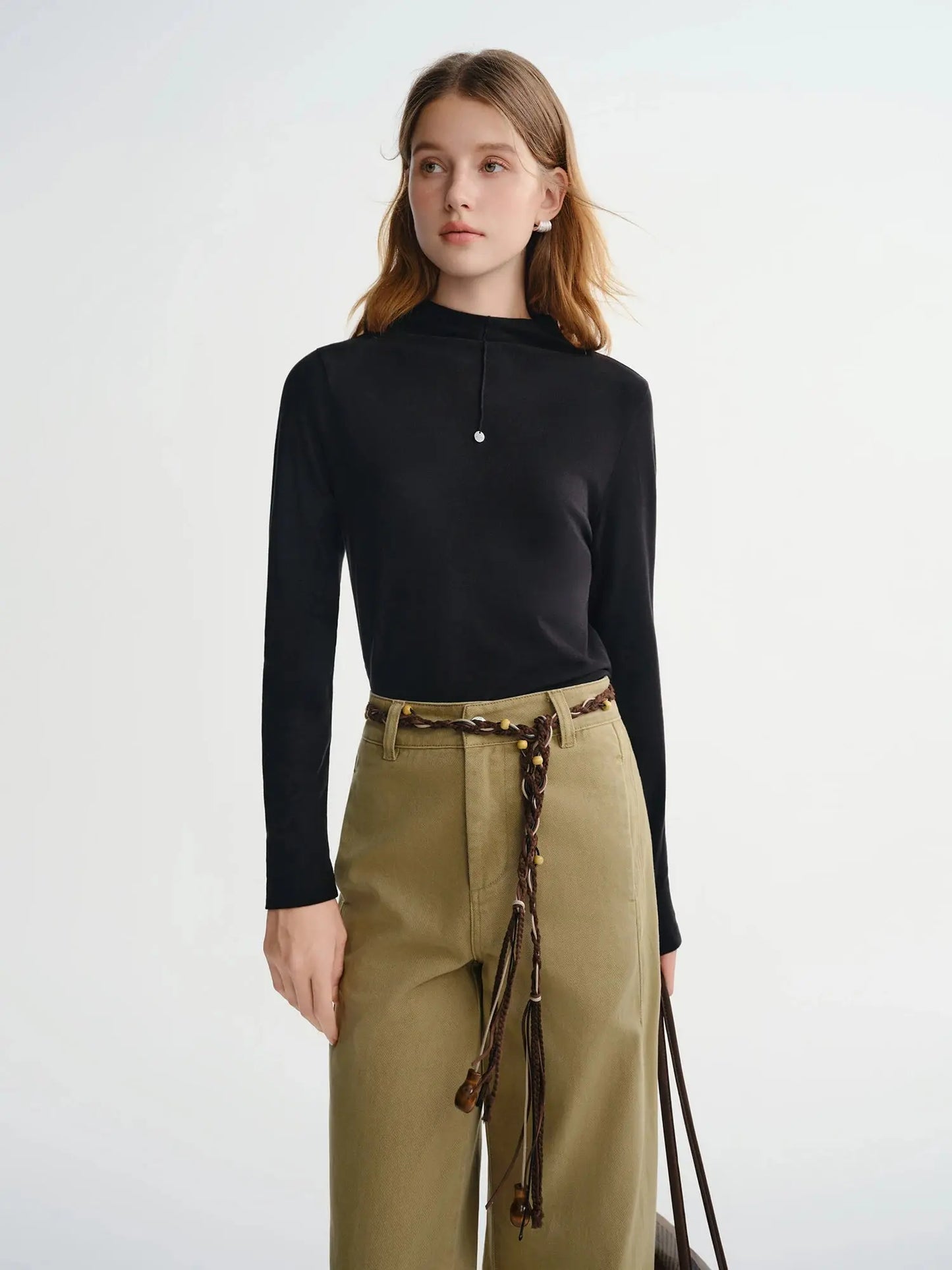 Woman wearing a black top and green pants 