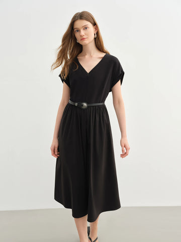 Woman wearing a black dress with a belt against a white background