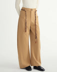 Beige wide-leg pants with decorative elements on a white background