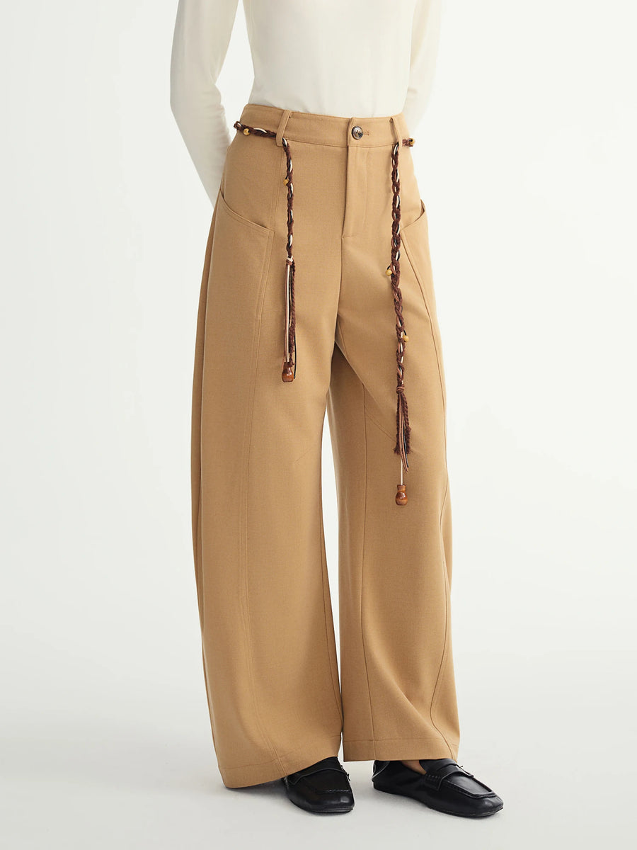 Beige wide-leg pants with decorative elements on a white background