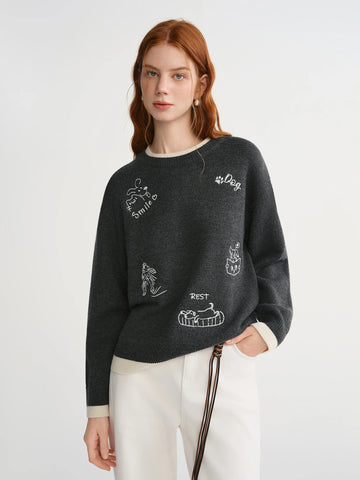 Woman wearing a dark gray sweater with white text and graphics on a light gray background