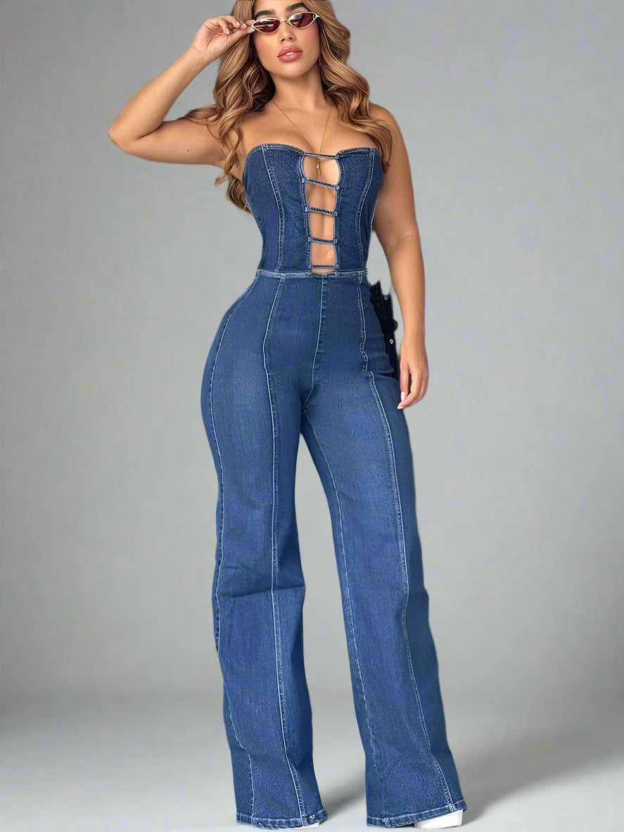 Woman wearing a blue denim jumpsuit against a neutral wall.