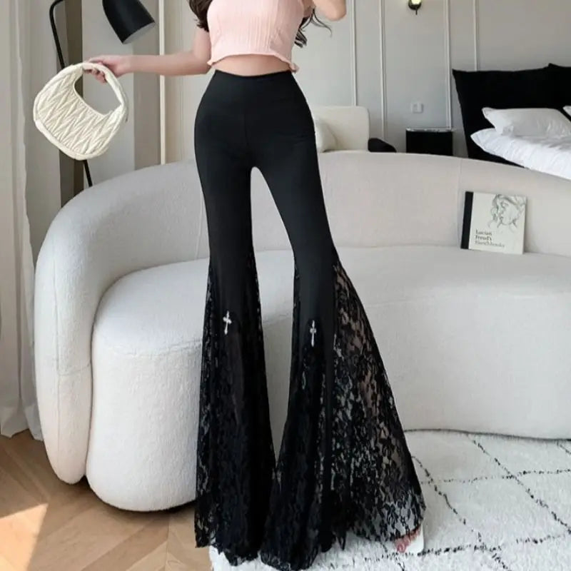 Person wearing black lace pants in a modern living room.