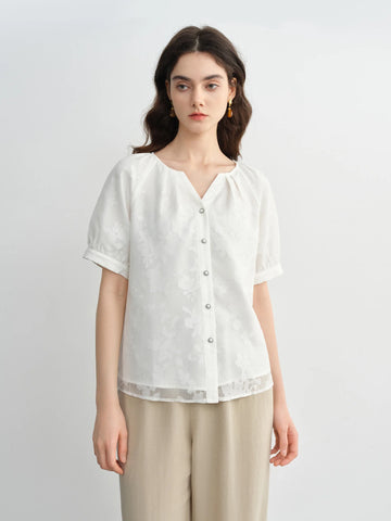 Woman wearing a white blouse with a plain background