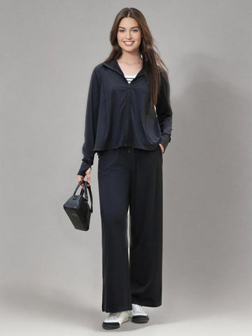 Woman wearing a navy tracksuit with a gray background