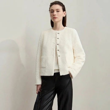 Woman wearing a white textured jacket with black pants on a plain background, featuring the brand 'Amii'.