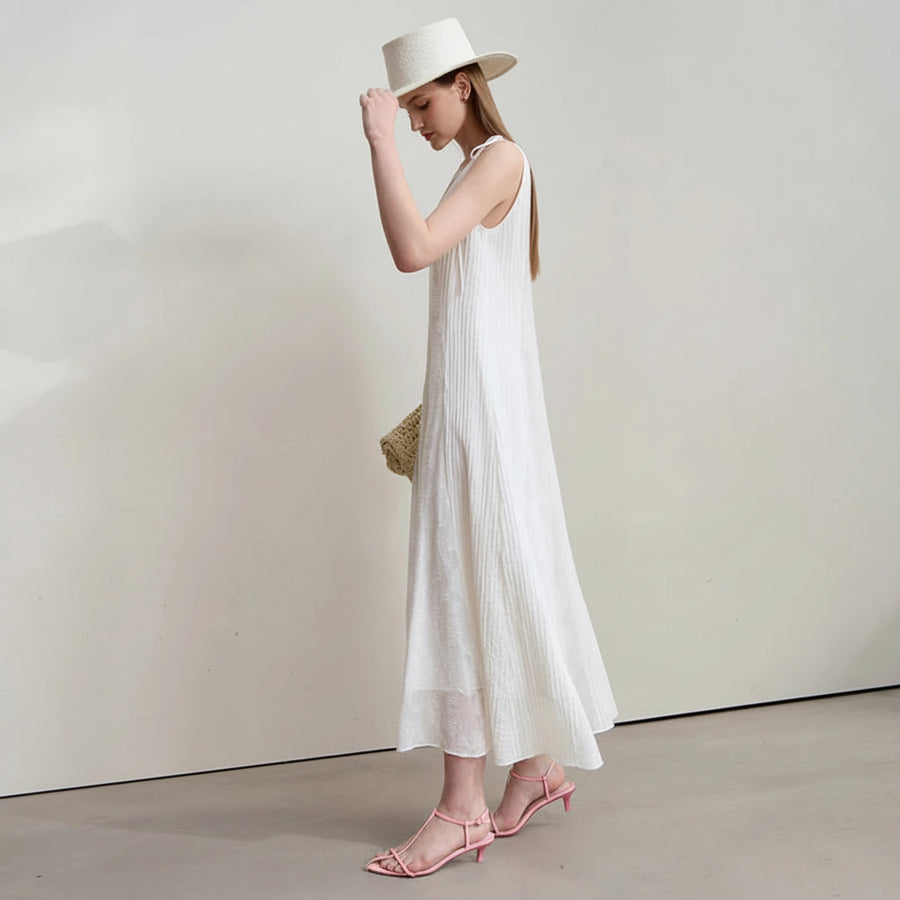 Woman wearing a white dress and hat with a minimal background, featuring the brand 'Amii'.