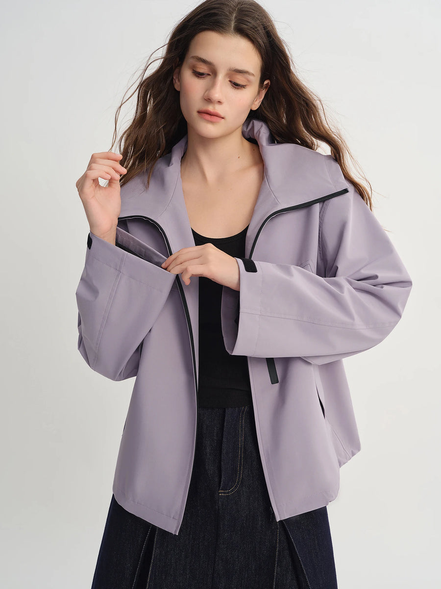 Woman wearing a light purple jacket on a plain background