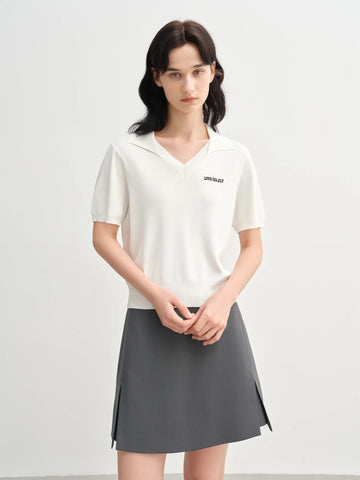 Woman wearing a white polo shirt and gray skirt on a white background